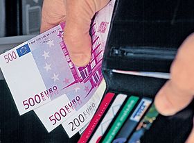 Hand mit großen Geldscheinen und Geldbeutel