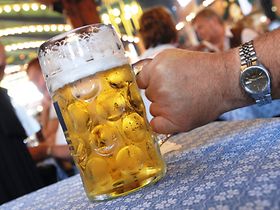 Hand mit Masskrug in Bierzelt