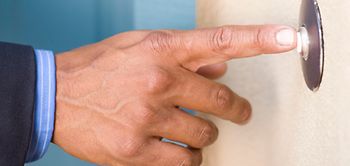 Hand mit Türklingel