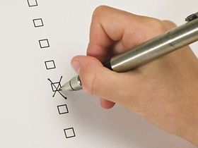 Hand setzt Kreuz auf der Liste