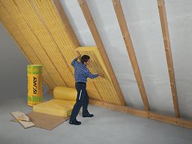 Handwerker bringt Isolierung innen auf dem Dach an