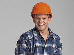 Handwerker traegt Ziegelsteine