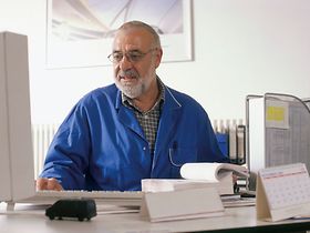 Handwerks-Meister im Buero am Computer