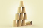 Illustration of plastic cups stacked in a pyramid with one fallen down, studio shot on beige backgro