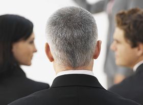 Hinterkopf grauhaariger Mann im Team