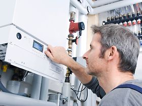 Installateur ueberprueft Heizung