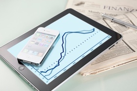 iPhone und iPad liegen auf Finanzzeitung