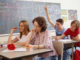 Jugendliche Schueler in Schulklasse