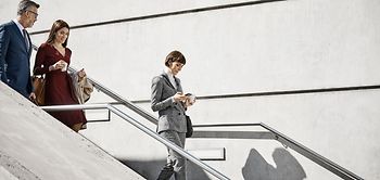 Male and female coworkers moving down on steps. Professionals are