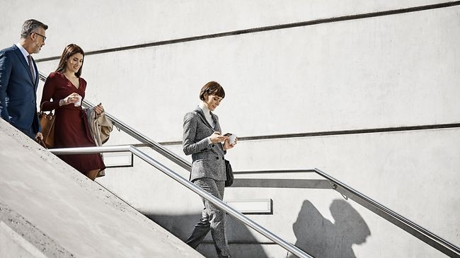 Male and female coworkers moving down on steps. Professionals are