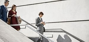 Male and female coworkers moving down on steps. Professionals are