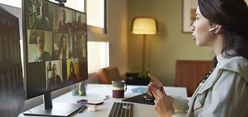 Junge Businessfrau diskutiert per Videocall