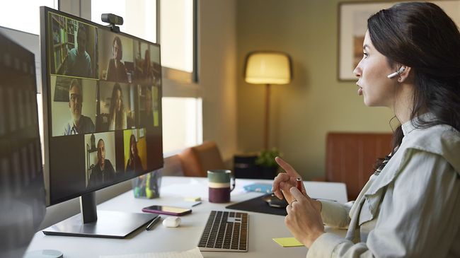 Junge Businessfrau diskutiert per Videocall