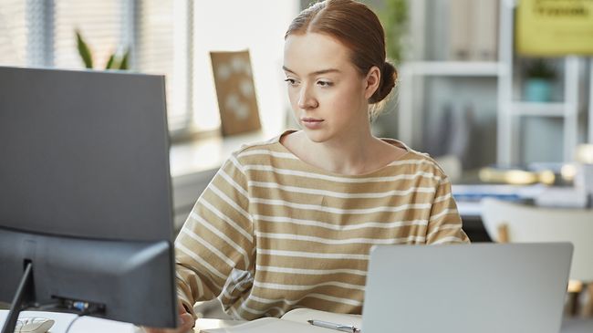 junge Frau bearbeitet Dokumente an PC