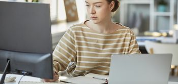 junge Frau bearbeitet Dokumente an PC
