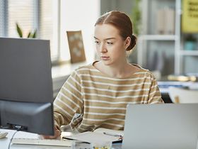 junge Frau bearbeitet Dokumente an PC