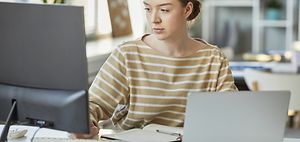 junge Frau bearbeitet Dokumente an PC