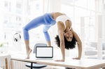junge Frau macht Yoga auf ihrem Schreibtisch