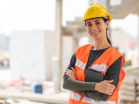 Junge Frau mit Schutzhelm und Sicherheitsweste