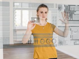 junge Frau organisiert Hausmodell an virtuellem Touchscreen
