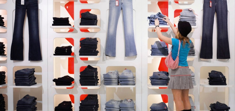 Junge Frau steht vor Regal einer Boutique