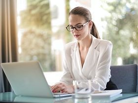 Junge Frau tippend am Laptop