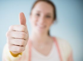 Junge Frau zeigt Daumen hoch