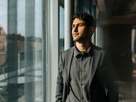 Junger Mann schaut aus dem Fenster (1)