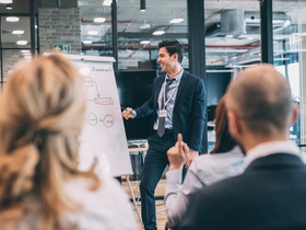 Junger Mann vor Flipchart - Weiterbildung, Fortbildung, Seminar