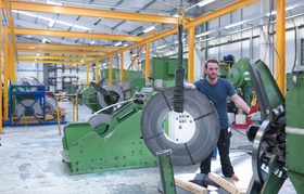 15 Jun 2015, England, UK --- Worker loading rolls of metal into stamping machine in engineering fact