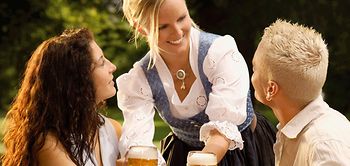 Kellnerin und zwei Gäste im Biergarten