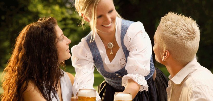 Kellnerin und zwei Gäste im Biergarten