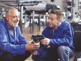 Kfz-Meister mit Lehrling in Autowerkstatt