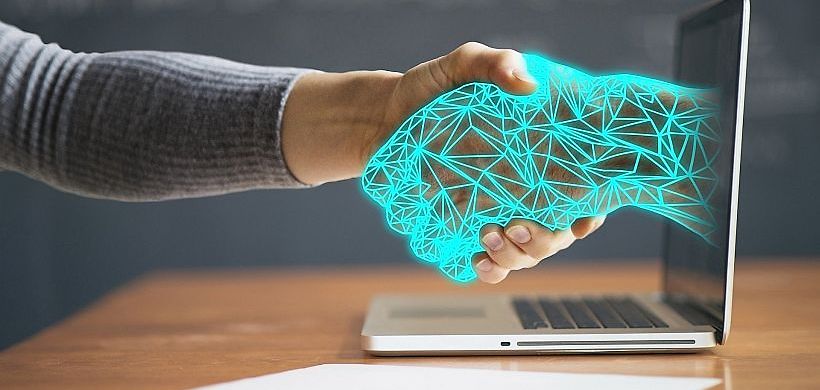 KI-Hand aus Laptop gibt Mensch die Hand