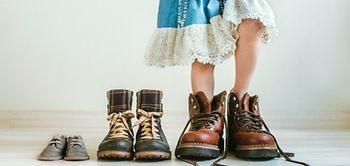 Kind in Schuhen von Erwachsenen