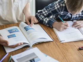 Kinder arbeiten zusammen an Arbeitsbuch