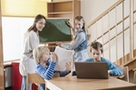 Kinder lernen an Tafel und Computer