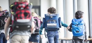 Kinder rennen in die Schule