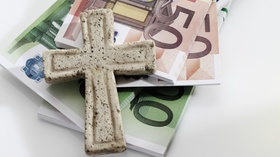 Bundle of euro notes with cross on white background