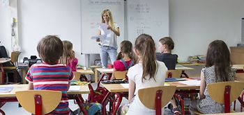 Klassenraum mit Lehrer und Kindern in der Grundschule