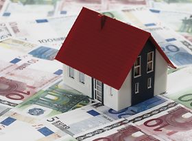 Kleines Hausmodell steht auf Geldscheinen