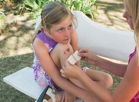 Kleines Mädchen bekommt von erwachsener Person ein Pflaster auf v