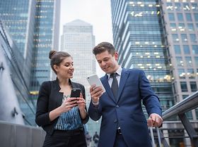 Kollegen benutzen Smartphone unterwegs