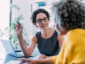 Shot of two beautiful businesswomen sharing ideas during a meeting in the office. Businesswomen disc