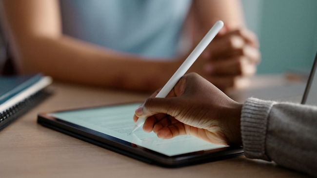 Kollegen schreibt mit Stift auf dem Tablet