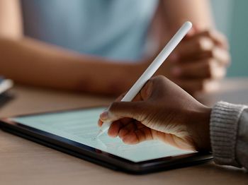 Kollegen schreibt mit Stift auf dem Tablet