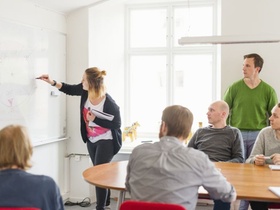 Young woman drawing on white board during work meeting