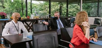 Konferenz: Menschen mit Masken und Abstand