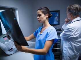 Krankenschwester und Arzt betrachten Röntgenbilder