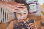 Krankes Kind mit Thermometer im Mund